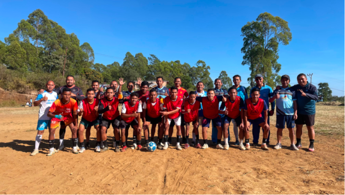Tim guru dan murid berfoto bersama sebelum pertandingan sepak bola pembuka.